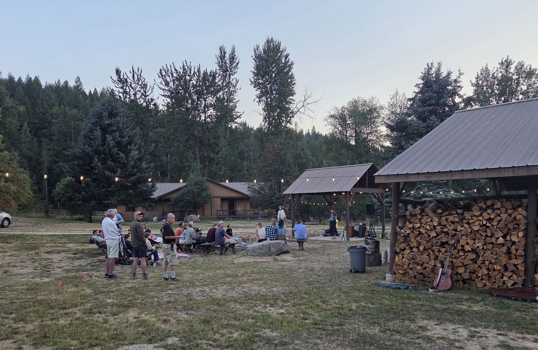 Friends gathered on the lawn by the woodshed at dusk